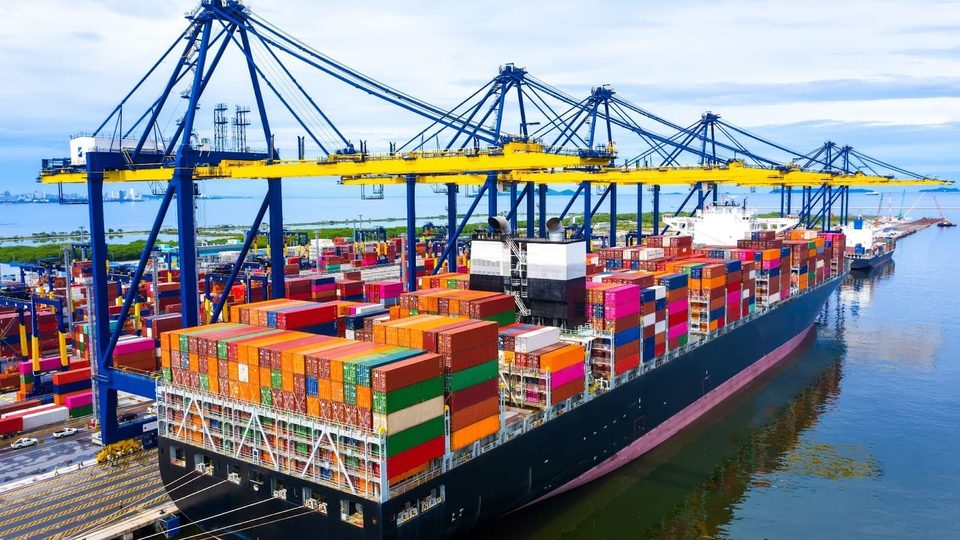 Container ship loading at port cranes for international glove export shipments