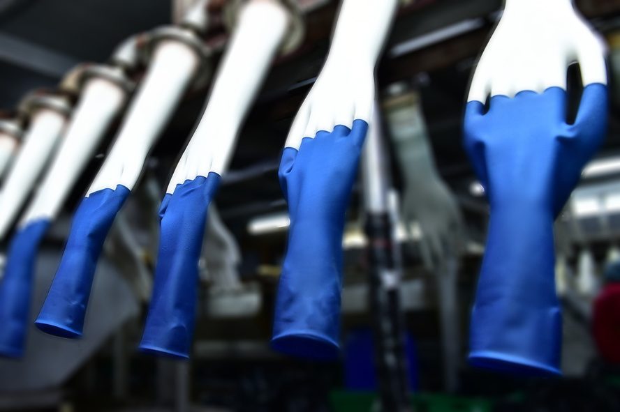 Blue examination gloves moving along the dipping line